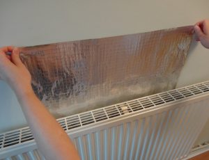 Radiator foil being fitted behind a radiator